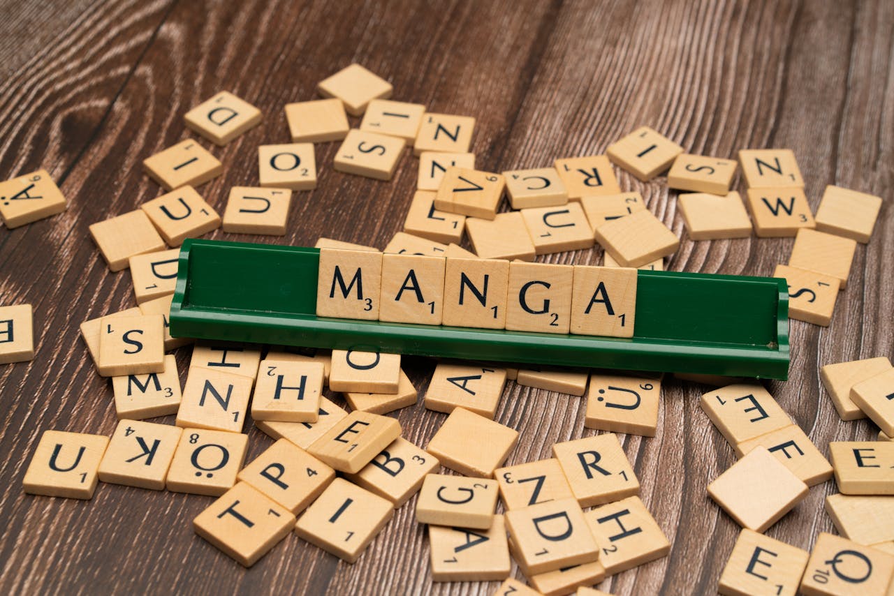 Scrabble tiles forming the word 'Manga' on a wood background. Ideal for book and culture themes.